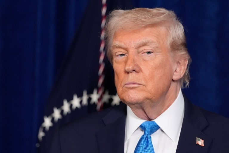 President Donald Trump listens as Defense Secretary Pete Hegseth speaks