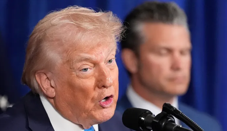 President Donald Trump speaks at his Mar-a-Lago club, Saturday, Jan. 3, 2026, in Palm Beach, Fla., as Defense Secretary Pete Hegseth listens. (AP Photo/Alex Brandon)