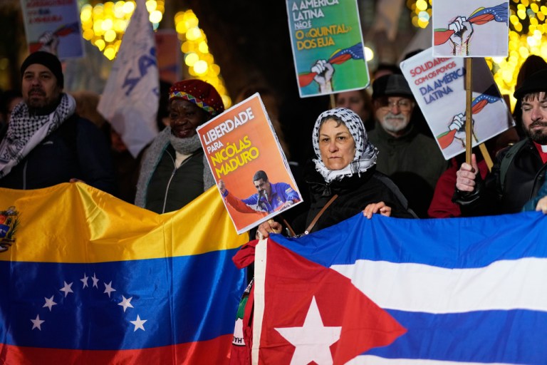 Demonstrators hold the flags of Venezuela and Cuba in Lisbon, Spain