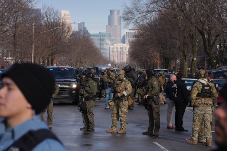 Law enforcement agents stand on the scene of a shooting in Minneapolis.