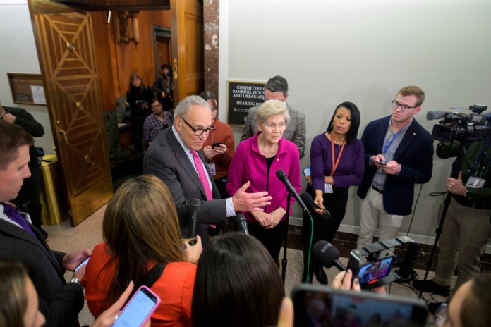Senate Minority Leader Charles Schumer, D-N.Y., left, and Sen. Elizabeth Warren, D-Mass., right, talk with reporters prior to attending a round table discussion on the high cost of housing, on Capitol Hill, Wednesday, Jan. 7, 2026, in Washington. (AP Photo/Rod Lamkey, Jr.)