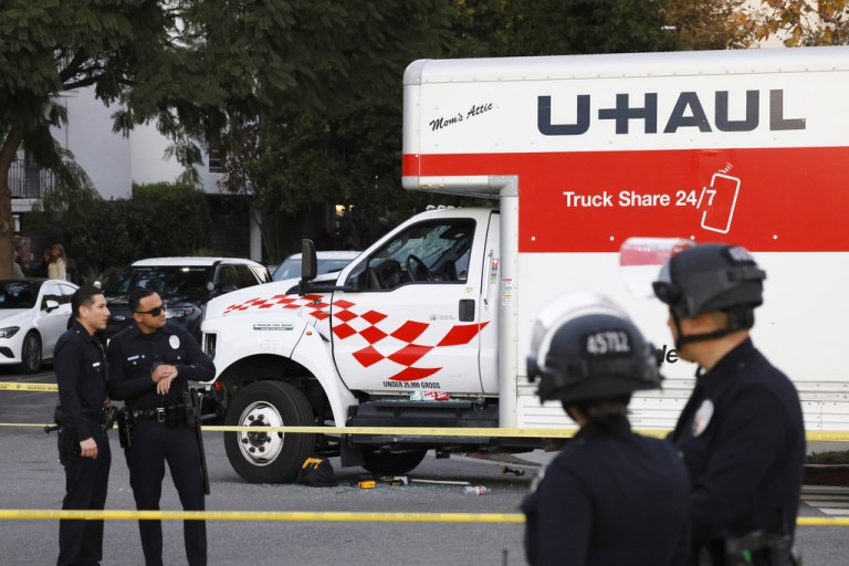 A U-Haul truck, which was driven into a group of protesters, is surrounded by LAPD officers after an incident.