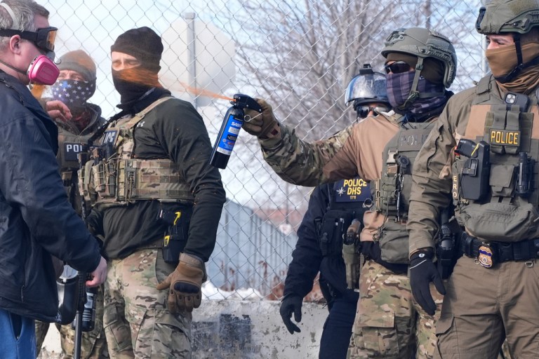 An Immigration and Customs Enforcement agent shoots pepper spray at a protester in Minneapolis.