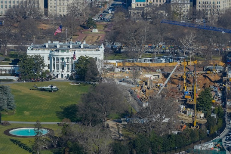 A Marine One helicopter lands on the South Lawn of the White House to transport President Donald Trump to nearby Andrews Air Force Base, as work continues on the construction of the ballroom where the East Wing once stood at the White House.