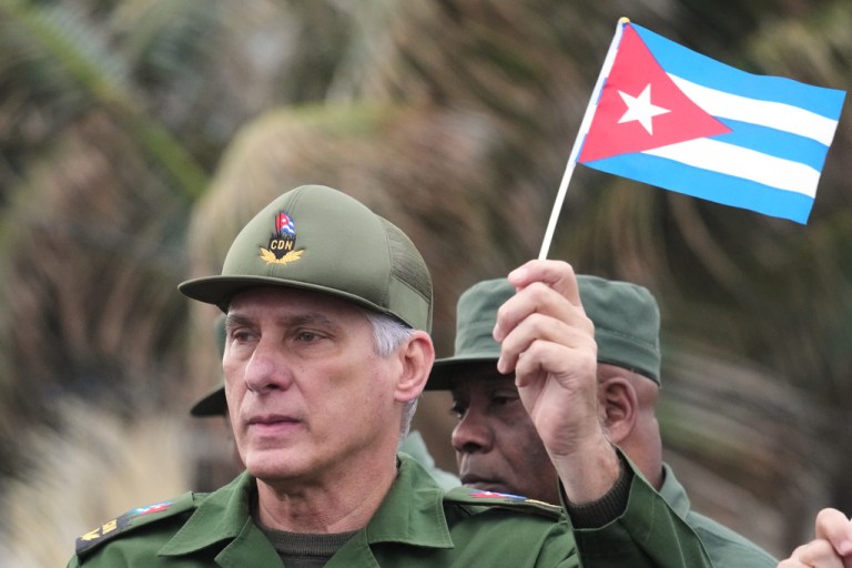 Cuban President Miguel Diaz-Canel waves a Cuban flag at a January 2026 rally opposing U.S. intervention in Venezuela.