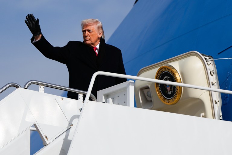 President Donald Trump waves while boarding Air Force One.