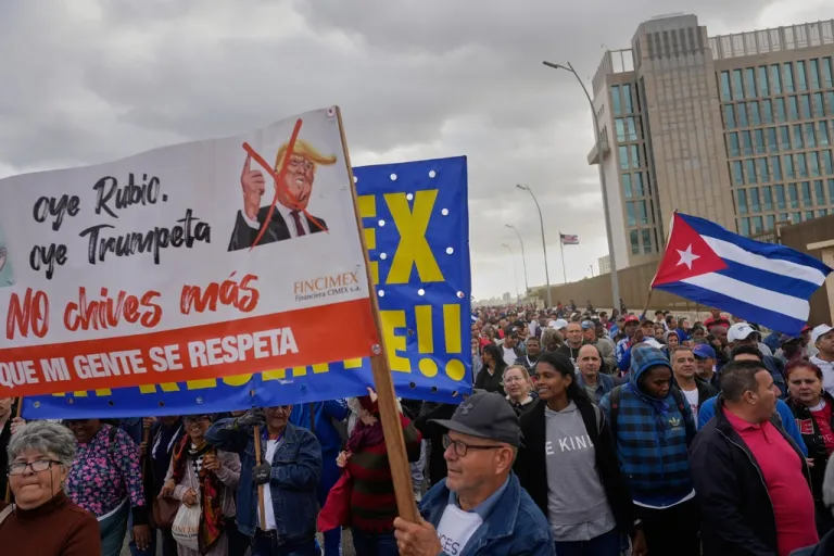 People holding a banner against President Donald Trump.