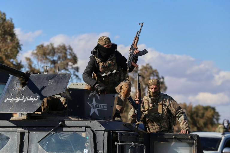 Soldiers of the Kurdish-led, U.S.-backed Syrian Democratic Forces deploy with armored military vehicles to secure roads leading to Gweiran Prison which houses men accused of being Islamic State group fighters in Hassakeh, northeastern Syria, Monday, Jan. 19, 2026. (AP Photo/Baderkhan Ahmad)
