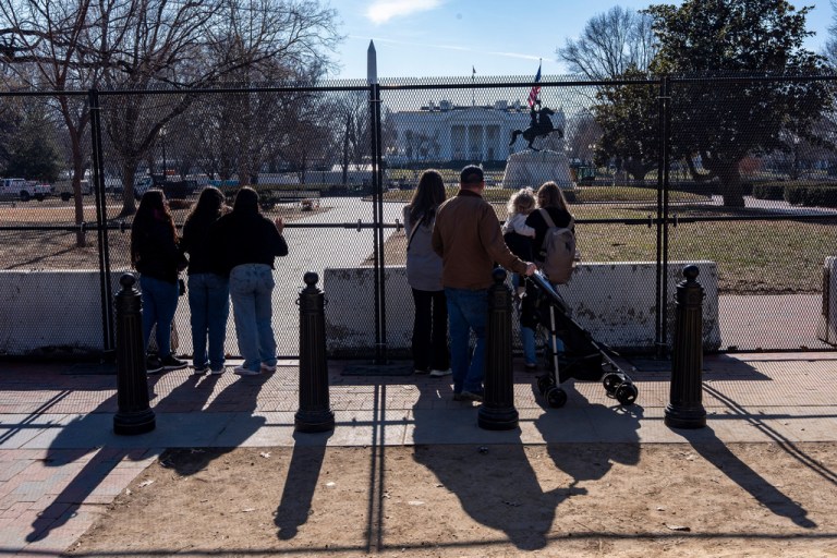 People look through the fencing placed around Lafayette Park near the White House while renovations are underway, Jan. 22, 2026, in Washington.