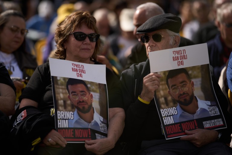 People hold signs with a photo of Ran Gvili, who was killed while fighting Hamas militants during the Oct. 7, 2023, terrorist attack and whose body has been held in Gaza ever since, during a rally calling for his return in Tel Aviv.