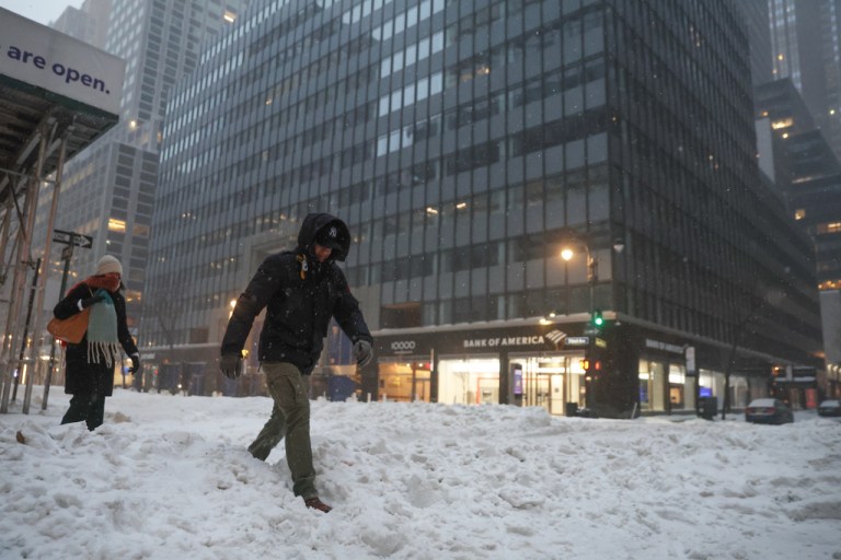 Pedestrians cross the street during a winter storm, Sunday, Jan. 25, 2026, in New York.