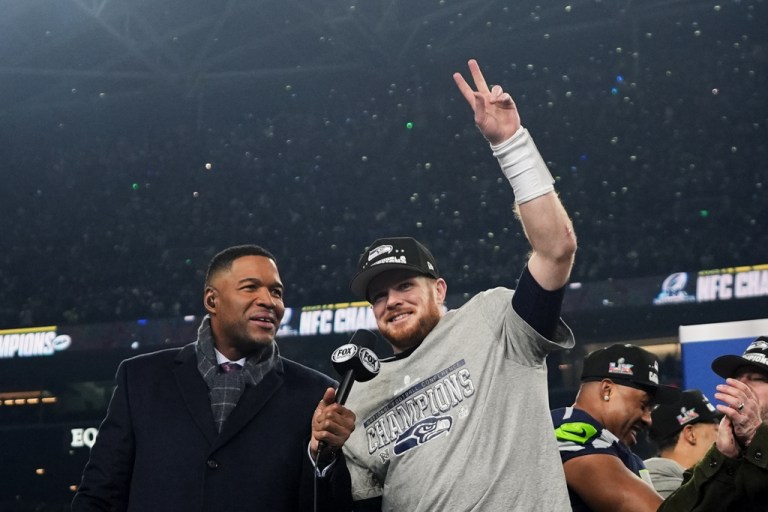 Seattle Seahawks quarterback Sam Darnold celebrates next to Michael Strahan after a win over the Los Angeles Rams in the NFC Championship NFL football game.