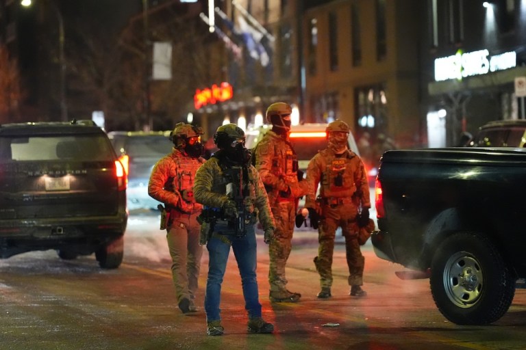 Federal agents stand guard as they try to clear the demonstrators near a hotel during a noise demonstration protest in response to federal immigration enforcement operations in the city Sunday, Jan. 25, 2026, in Minneapolis. (AP Photo/Adam Gray)