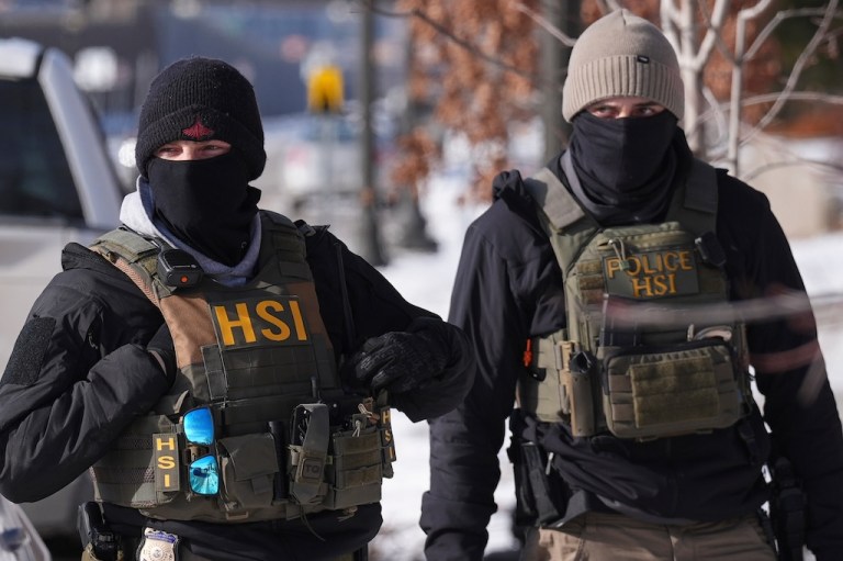 Federal agents stand outside of a property in St. Paul, Minneapolis.