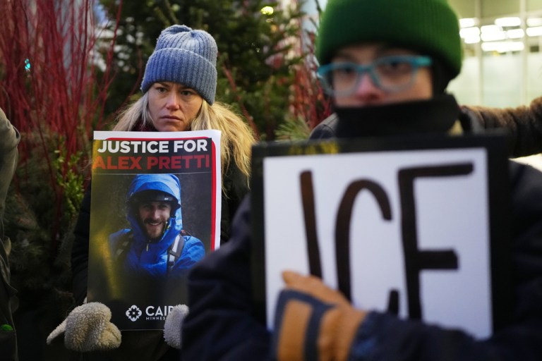 Demonstrators hold signs during a protest outside the office of Sen. Amy Klobuchar in Minneapolis