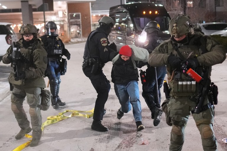 Law enforcement officers detain a demonstrator during a protest outside SpringHill Suites and Residence Inn by Marriott hotels on Monday, Jan. 26, 2026, in Maple Grove, Minn. (AP Photo/Adam Gray)