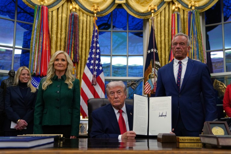 President Donald Trump holds a sign executive order on addiction recovery.