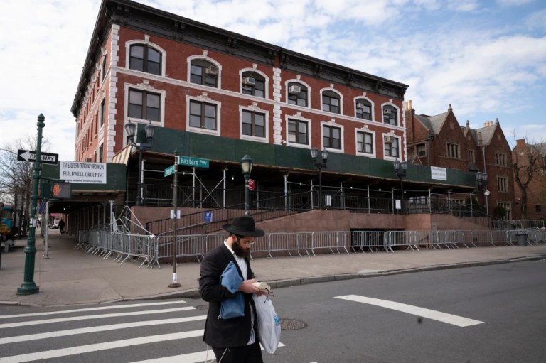 A man passes the Chabad-Lubavitch World Headquarters in the Crown Heights neighborhood of Brooklyn, April 7, 2020 in New York. (AP Photo/Mark Lennihan, File)