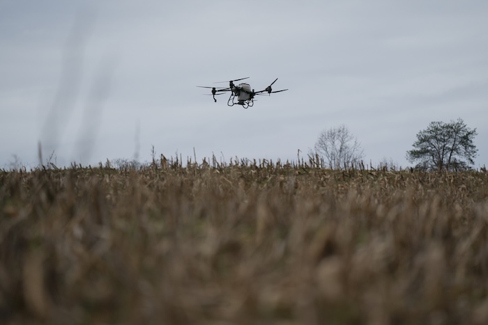 A DJI drone puts crop cover on a farm.