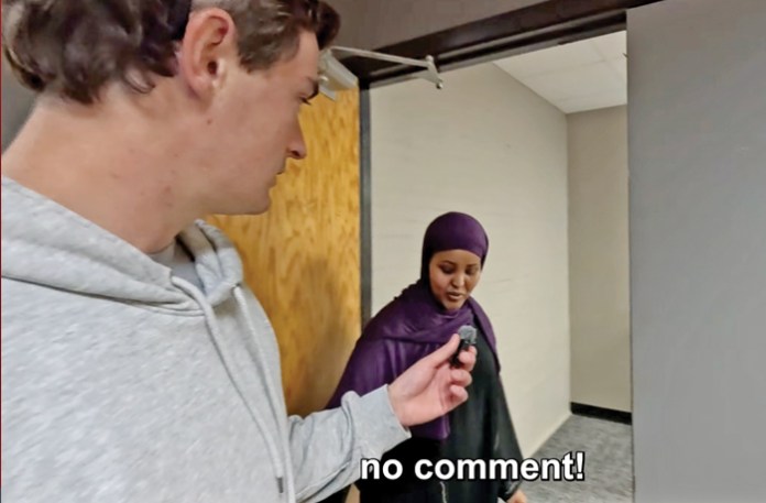In a captioned video posted by YouTuber Nick Shirley, left, a worker at a Somali-American business in Minnesota allegedly receiving government funds declines to answer questions. (Nick Shirley/YouTube)