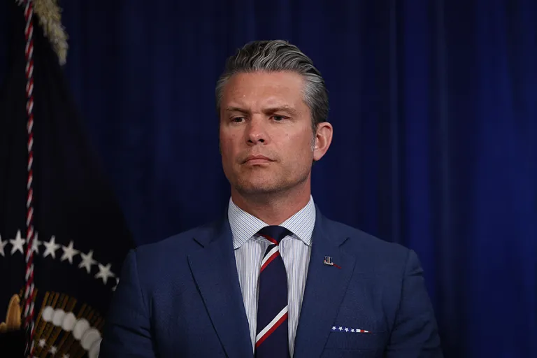 Secretary of War Pete Hegseth listens as U.S. President Donald Trump addresses the media during a news conference at his Mar-a-Lago club on Jan. 3, 2026, in Palm Beach, Florida. President Trump confirmed that the U.S. military carried out a large-scale strike in Caracas overnight, resulting in the capture of Venezuelan leader Nicolas Maduro and his wife, Cilia Flores. (Photo by Joe Raedle/Getty Images)