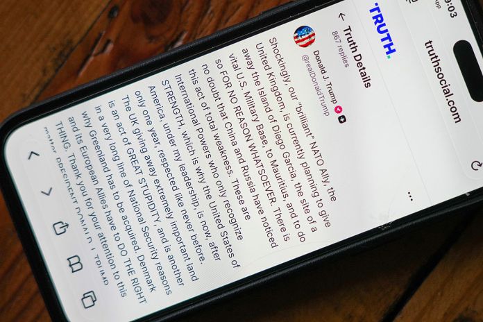 A phone shows a post on Truth Social by President Donald Trump critisizing the UK's handover of the Chagos Islands on January 20, 2026. (Christopher Furlong/Getty Images)