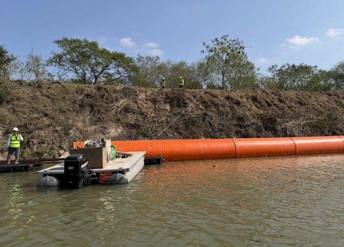 Construction crews install the first buoys in the Rio Grande, which divides the United States and Mexico.