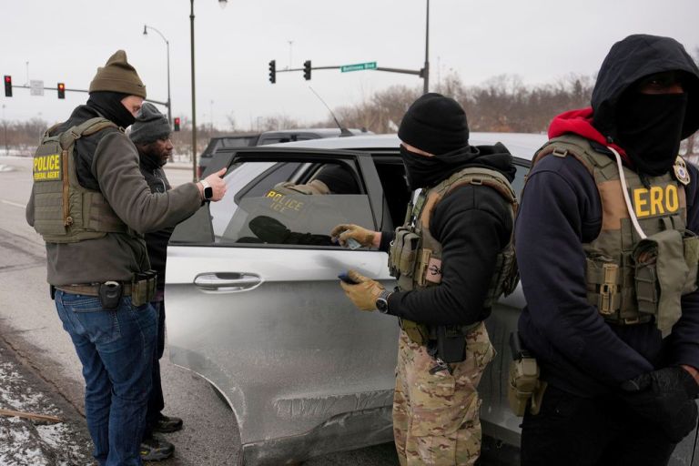 Immigration and Customs Enforcement officers detain a man during a traffic stop.