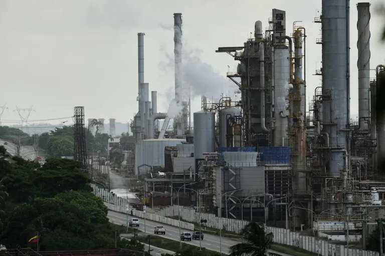 Vehicles drive past the El Palito refinery in Puerto Cabello, Venezuela.