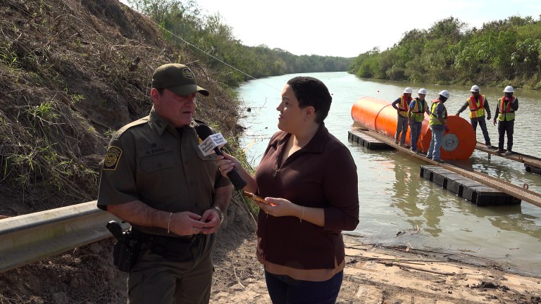 The Washington Examiner's Anna Giaritelli interviews a Border Patrol agent on the banks of the Rio Grande as workers lay a wall of buoys.