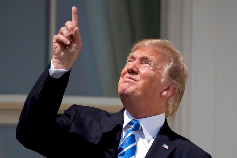 In this Aug. 21, 2017, file photo, President Donald Trump points to the sun