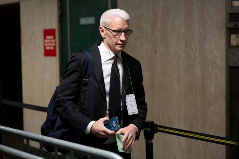 Anderson Cooper walks through a court house in New York