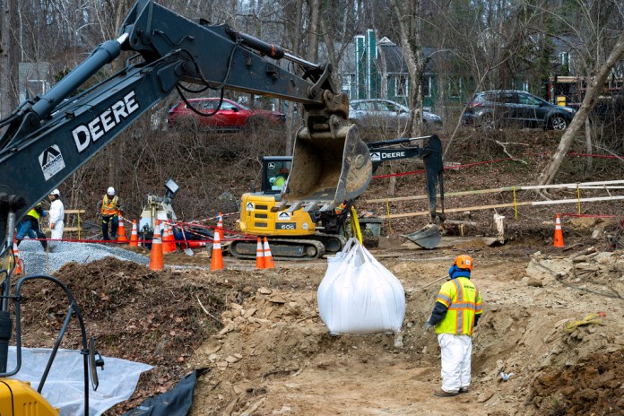 Federal employees work to put up a cofferdam to redirect sewage flow away from the Potomac