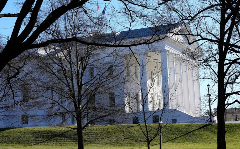 The state and U.S. flags fly over the Virginia State Capitol.
