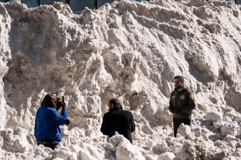New York City Mayor Zohran Mamdani, right, stands backdropped by a pile of snow while recording a video during a visit to the Department of Sanitation's snow melting operations in New York, Thursday, Jan. 29, 2026.