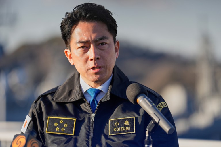 Japan's Defense Minister Shinjiro Koizumi speaks to reporters from a podium