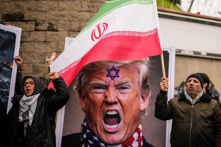 People shout next to a poster of President Donald Trump.