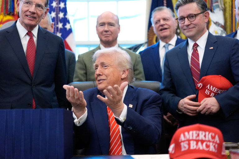 President Donald Trump speaks to reporters with hands up near his head after signing a spending bill that ends a partial shutdown of the federal government in the Oval Office of the White House, Tuesday, Feb. 3, 2026, in Washington. (AP Photo/Alex Brandon)