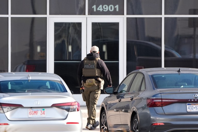 An ICE officer stands outside a warehouse as federal officials tour the facility to consider repurposing it as an ICE detention facility, Jan. 15, 2026, in Kansas City, Mo. (AP Photo/Charlie Riedel, file)