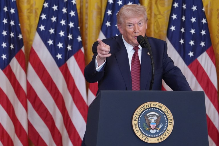President Donald Trump standing at podium and pointing