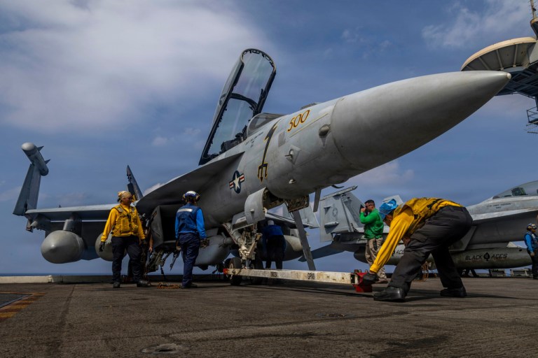 A U.S. fighter jet sits on an American aircraft carrier.