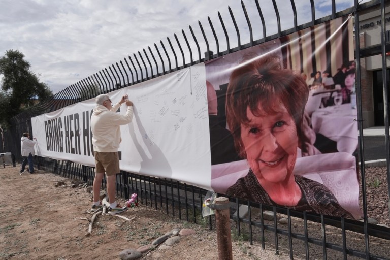 Jeff Robb signs a banner supporting Nancy Guthrie.