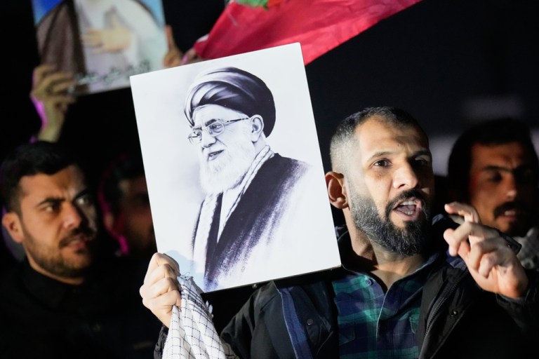 A protester holds a portrait of Iran's Supreme Leader Ayatollah Ali Khamenei during a protest against U.S. and Israeli attacks on multiple cities across Iran at a bridge leading to the fortified Green Zone where the U.S. Embassy is located in Baghdad, Iraq, Saturday, Feb. 28, 2026.