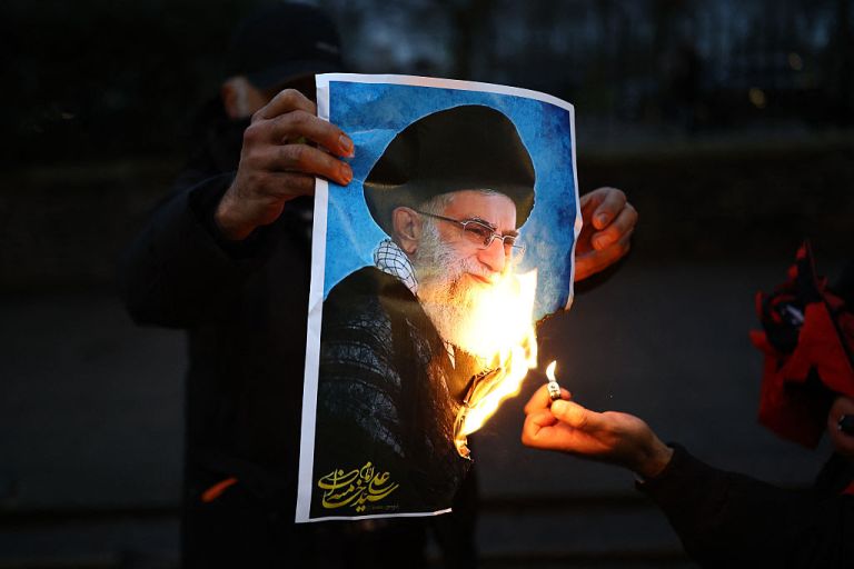 Anti-Iranian regime protesters burn an image of Ayatollah Ali Khamenei, during a gathering outside the Iranian Embassy, central London, on January 12, 2026.