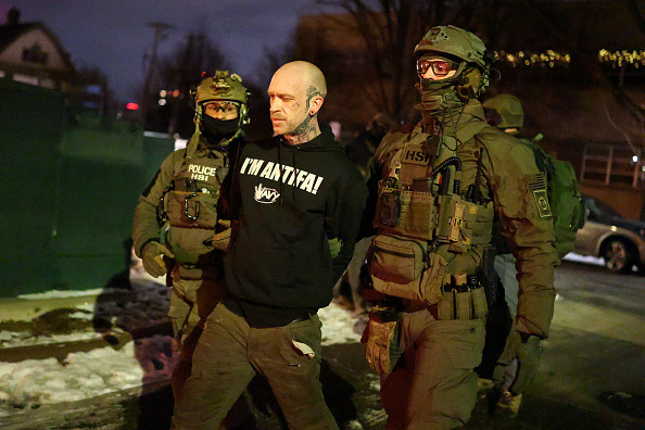 Federal agents with Homeland Security Investigations detain Kyle Wagner.