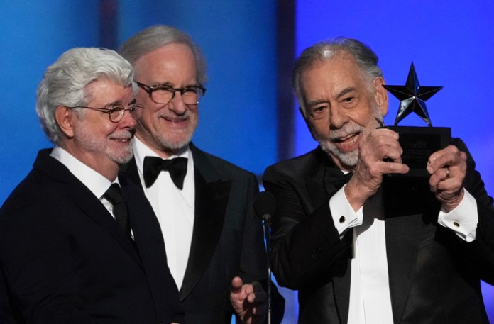 Filmmaker Francis Ford Coppola, right, accepts the 50th AFI Life Achievement Award from presenters George Lucas, left, and Steven Spielberg on Saturday, April 26, 2025, at the Dolby Theatre in Los Angeles. (Chris Pizzello/AP Photo)