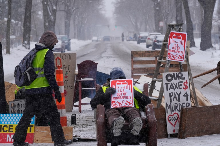 A person walks near a blockade set up to deter federal immigration enforcement vehicles In Minneapolis.