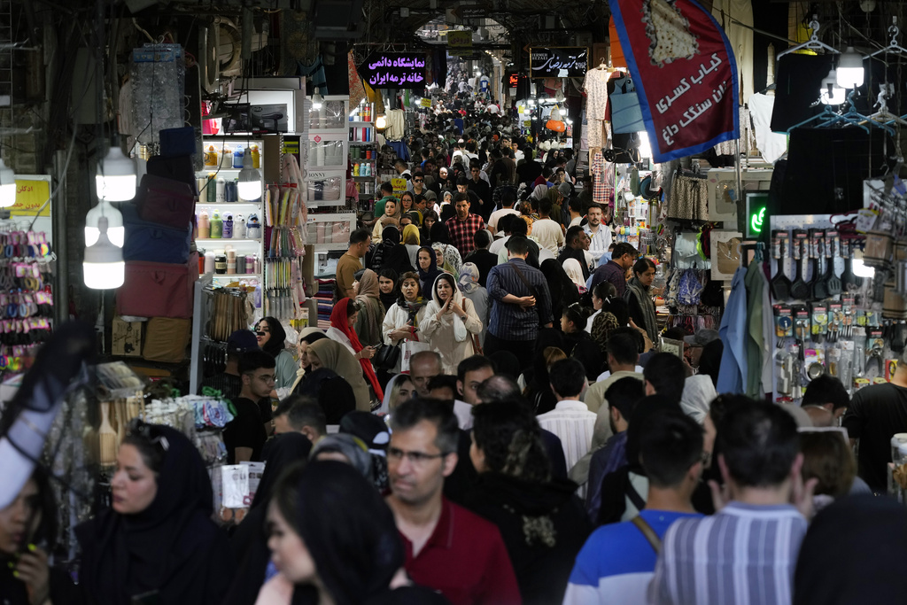 People walk through the old main bazaar of Tehran, Iran, Thursday, June 13, 2024. 