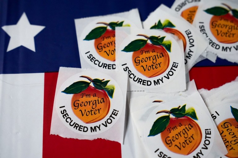 Stickers sit on a table inside a polling place, Tuesday, Nov. 5, 2024, in Atlanta