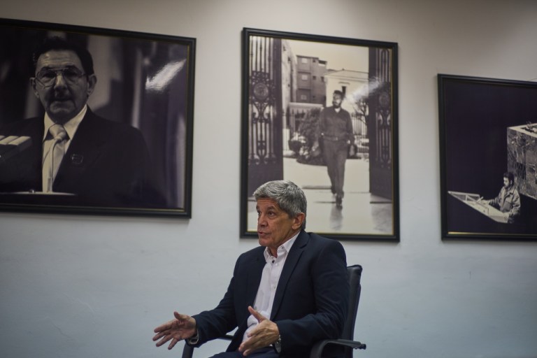 Carlos Fernández de Cossío sitting in front of black and white photos
